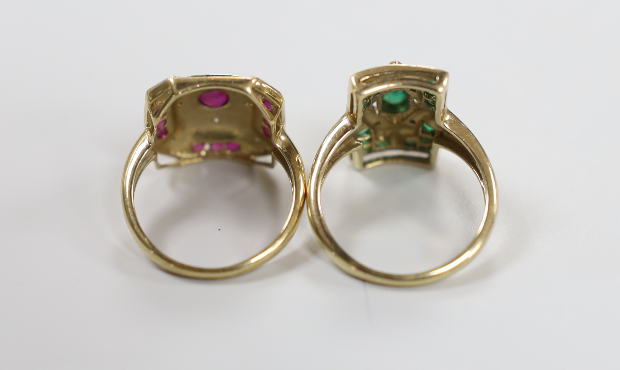 A modern 9ct gold, emerald and diamond chip cluster set table ring, size N and a similar ruby and diamond chip cluster set ring, gross weight 7.7 grams.